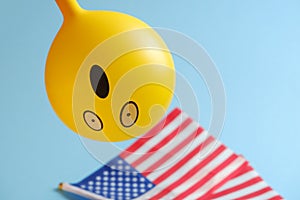 Yellow emoji balloons with American flags on a blue background.