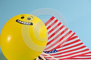 Yellow emoji balloons with American flags on a blue background.