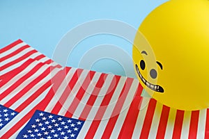 Yellow emoji balloons with American flags on a blue background.