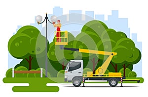 Yellow Engine Powered Scissor Lift. Worker with the help of an automobile tower change repairing a street pole.