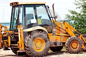 Yellow excavator, bulldozer machine and worker tractor. Road works. Road machinery at construction site.