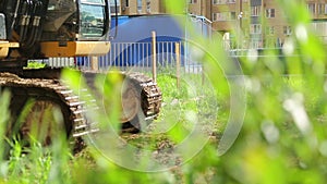 Yellow excavator on a construction site going