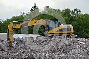 Yellow excavator at demolition site
