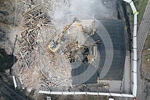 Yellow excavator destroys building. Heavy duty machine is demolishing a brick building. Demolition of the building . Demolition