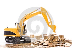 Yellow excavator digging a heap of coins