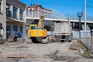 Yellow excavator and dump truck resting on a construction site