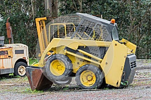 Yellow excavator in a grader parked