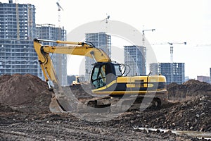 Yellow excavator during groundwork on construction site. Hydraulic backhoe on earthworks. Heavy equipment