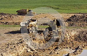 Yellow excavator and large yellow trucks