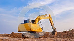 Yellow excavator is leveling the ground for construction area of industrial building in construction site against blue sky