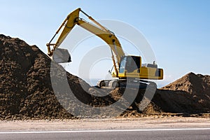 Yellow excavator loader machine during earthmoving works