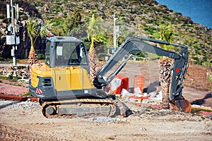 Yellow excavator performing excavation work in a construction site