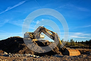 Yellow excavator on a road construction site