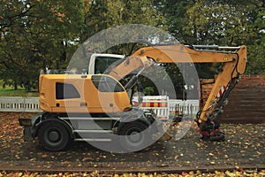 Yellow excavator in the street