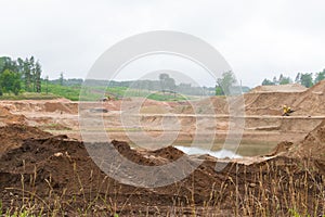 excavator and tractor at sandpit with water during earthmoving works