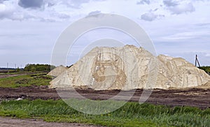 Yellow excavator working digging in sand quarry