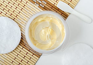 Yellow facial mask banana face cream, shea butter hair mask, body butter in a small white container. Natural skin care