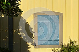 Yellow farm building blue barn door shadows