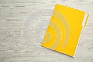 Yellow file with documents on white wooden table, top view. Space for text