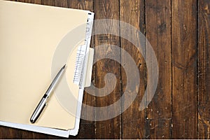 Yellow file folder and pen on wooden background