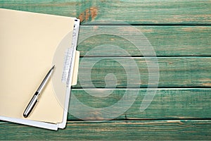 Yellow file folder and pen on wooden background