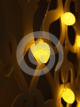 Yellow fir cones Christmas lights garland on dark background. Christmas or new year led lights garland. Blurred yellow glowing