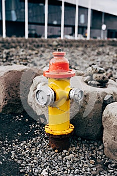 Yellow fire hydrant with red cap and silver lids.