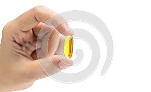 Yellow fish oil capsule pills in Asian woman hand isolated