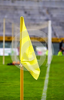 Yellow flag at one corner of football stadium and soccer corner of a soccer field