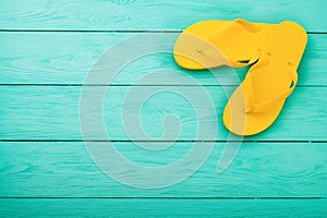 Yellow flip flops on blue wooden background. Summer beach holidays. Top view. Mock up. Copy space