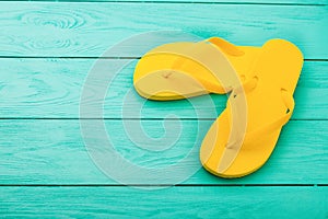 Yellow flip flops on blue wooden background. Summer holidays. Top view. Mock up. Copy space