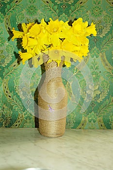 A yellow flower in a vase on a table