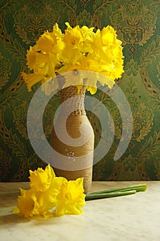 A yellow flower in a vase on a table