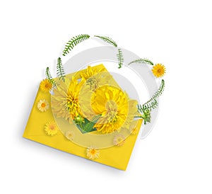 Yellow flowers and green leaves in yellow envelope. Flat lay. Top view. Rudbeckia flower and small yellow garden flowers. Valentin
