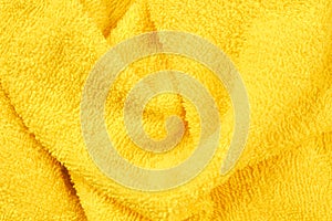 Yellow fluffy bath towel background.