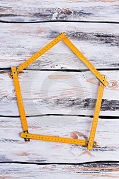 Yellow folding ruler forming shape of house.