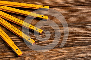 yellow folding ruler on wooden surface