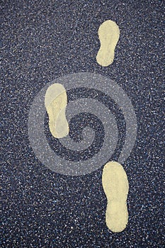 Yellow footsteps drawn in playground rubber flooring