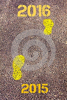 Yellow footsteps on sidewalk from Year 2015 to Year 2016 messages.New Years Concept image