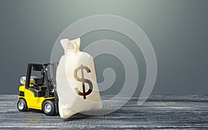 Yellow forklift carries a dollar money bag. Tax payment. Payment of taxes. Big contract, profitable deposit, take a loan. Wealth, photo