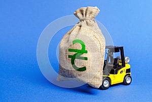 Yellow forklift carries a money bag with Ukrainian hryvnia symbol. Concept of a major contract, profitable deposit or loan.