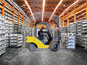 Yellow forklift lift aluminum pack stack inside warehouse. Material handling, storage and transportation concept.