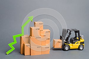 Yellow Forklift truck brings the box to a stack of boxes and a green arrow up. raise economic indicators. exports, imports. sales photo