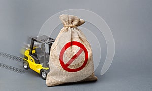 Yellow forklift truck can not lift the bag with the symbol NO. Economic pressure and sanctions. trade wars, stagnation photo