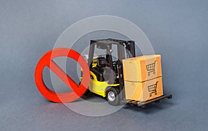 Yellow Forklift truck carries boxex and a red prohibition symbol NO. Embargo trade wars. Restriction on importation production photo