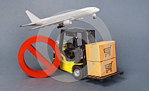 Yellow Forklift truck carries boxex and a red prohibition symbol NO. Embargo trade wars. Restriction on importation production photo