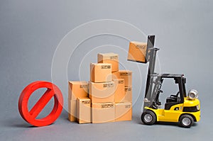 Yellow Forklift truck truckraises a box over a stack of boxes and a red symbol NO. Embargo trade wars. Restriction on importation photo