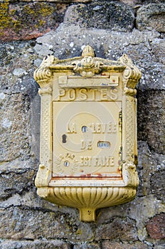 Yellow French Mailbox in Stone Wall