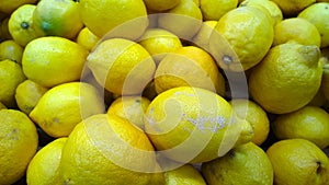 Yellow fresh lemons background. Fruits on supermarket shelves. Farmers market. Retail industry. Discount. Grocery shopping.