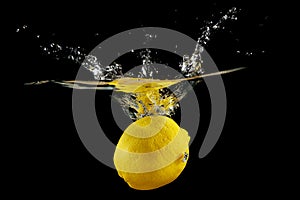 Yellow fresh lime fruit under water with reflection. Healthy cytrus lemon vegetable splashing into clear water while cooking.